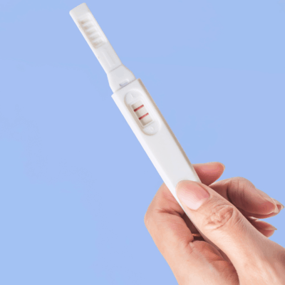 hand holding a pregnancy test after getting pregnant quickly