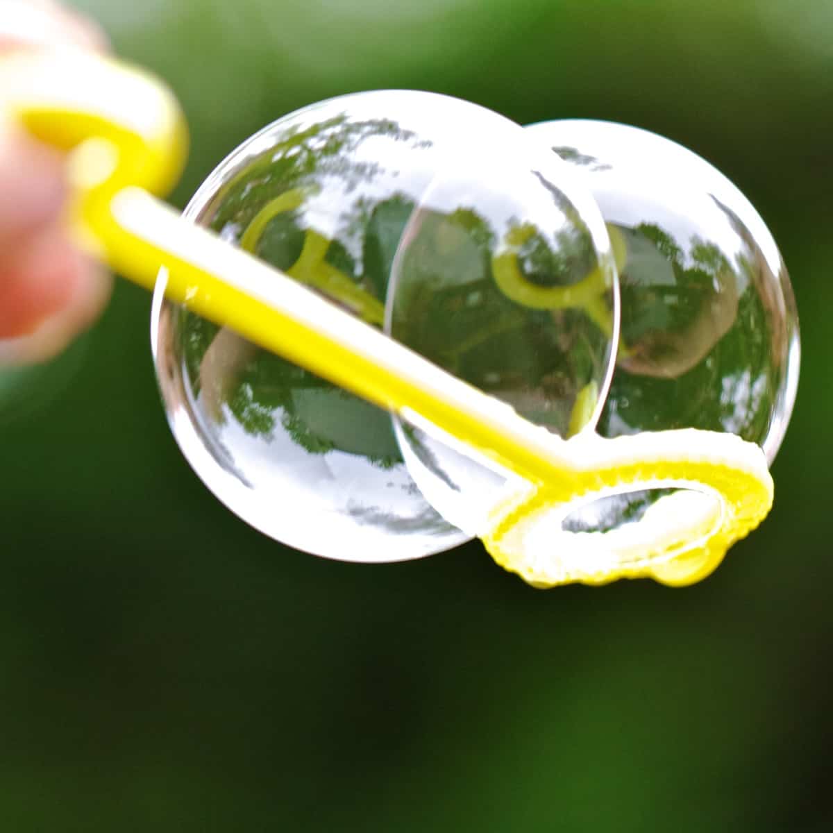 2 homemade bubbles on a yellow wand