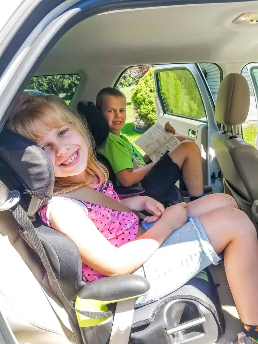 Girl in boy in backseat ready for a road trip