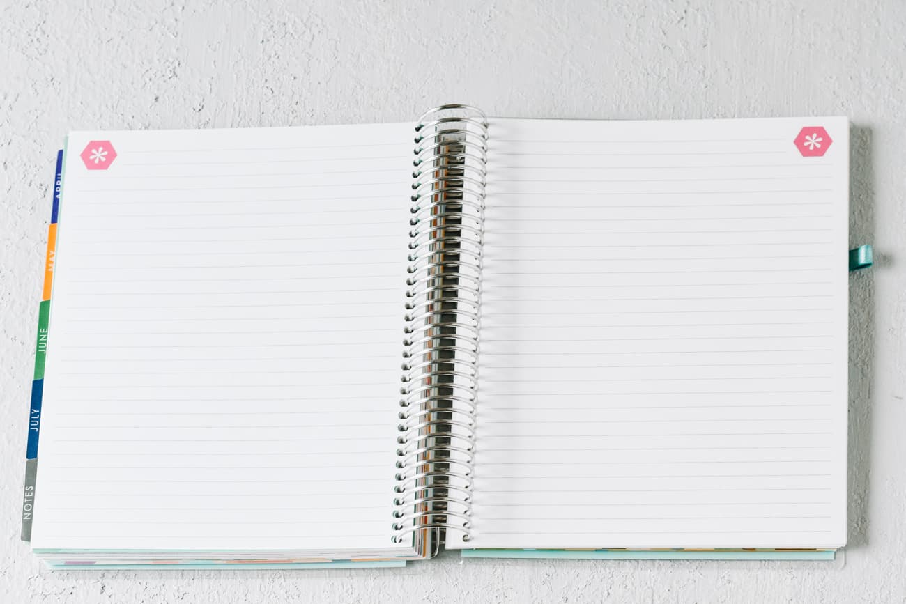 open pages of spiral bound notebook with tabs on the left side