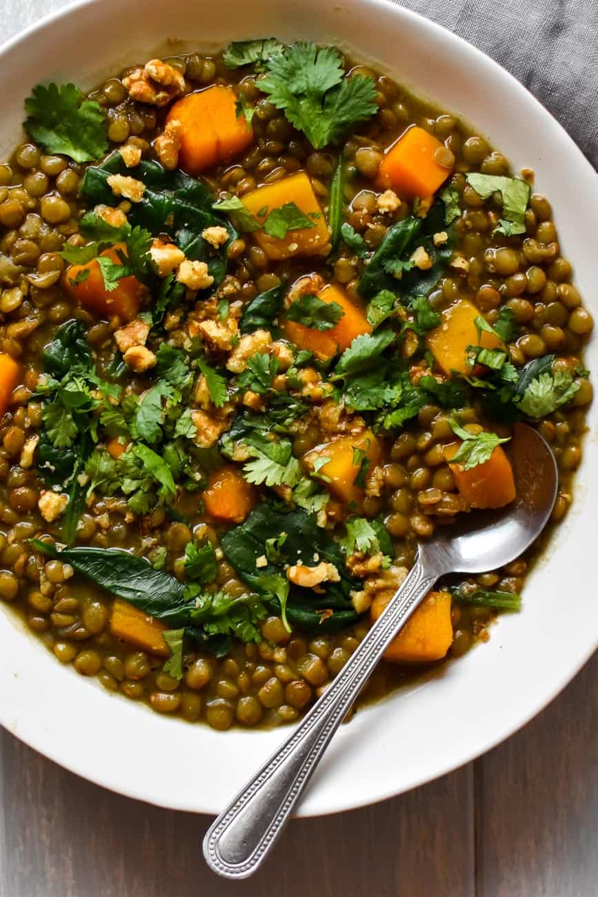 vegan lentil soup recipe in a white bowl with a spoon