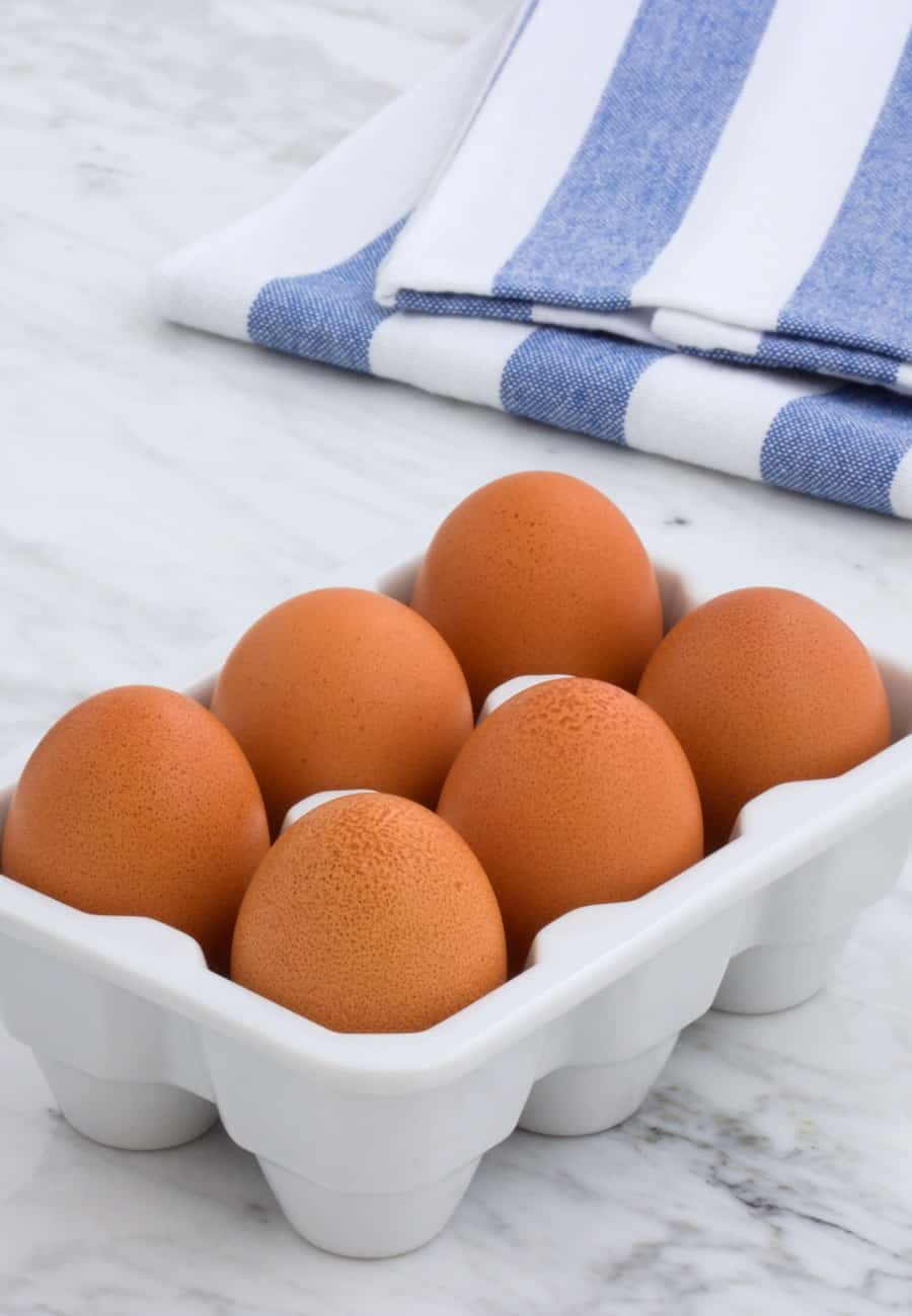 brown eggs in ceramic holder with towel