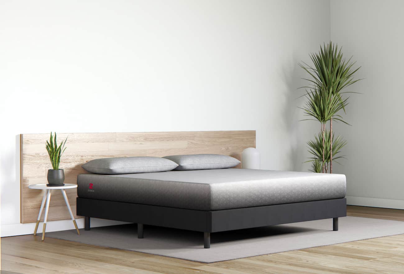 zoma mattress with two pillows in a minimalist room with two plants