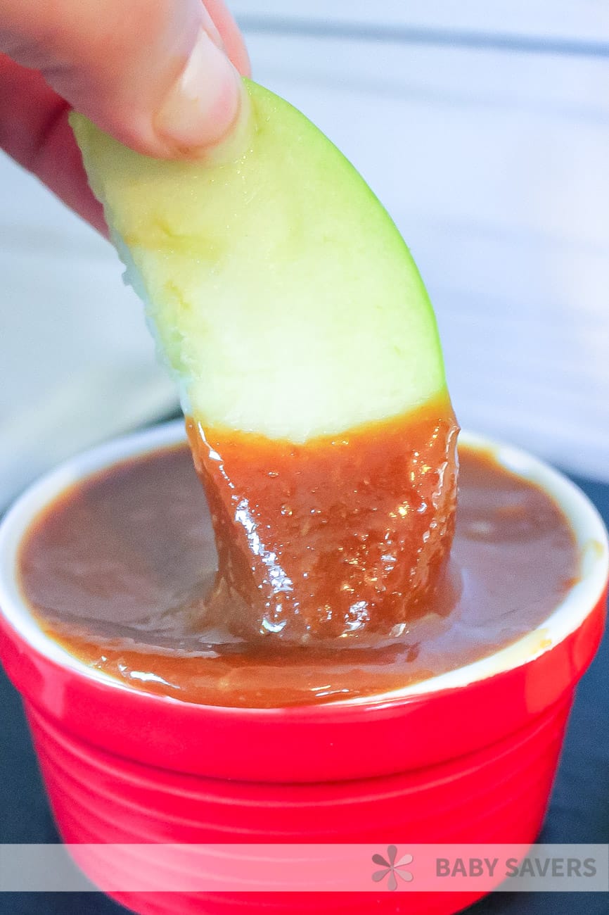 dipping green apple in homemade caramel