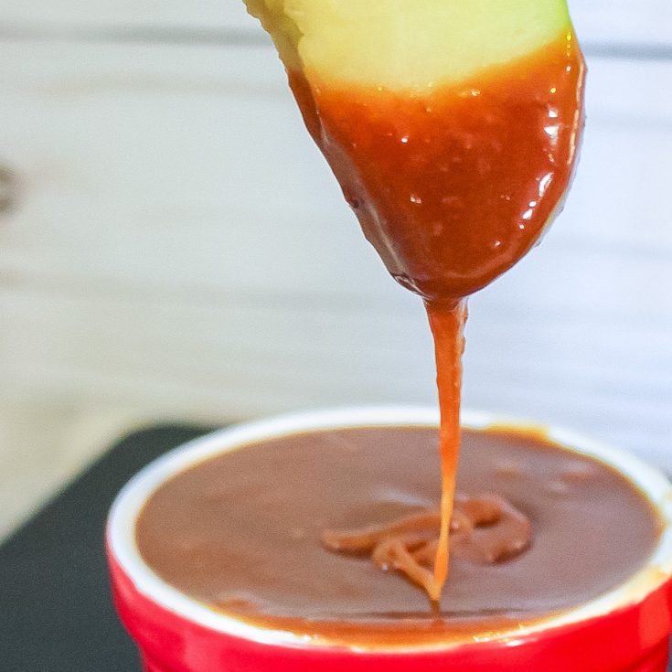 apple dipping in crockpot caramel