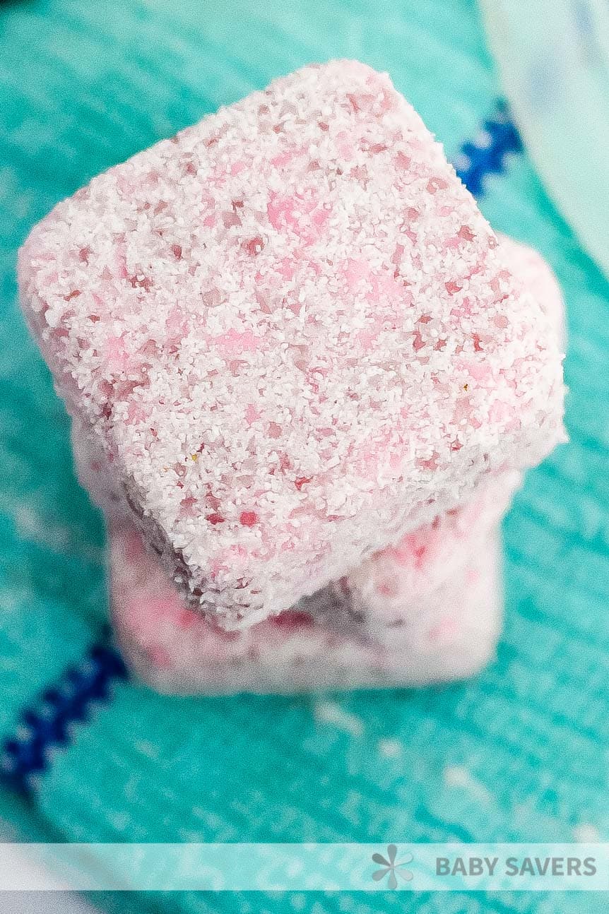 stacked pink cubs of DIY laundry soap on a green towel