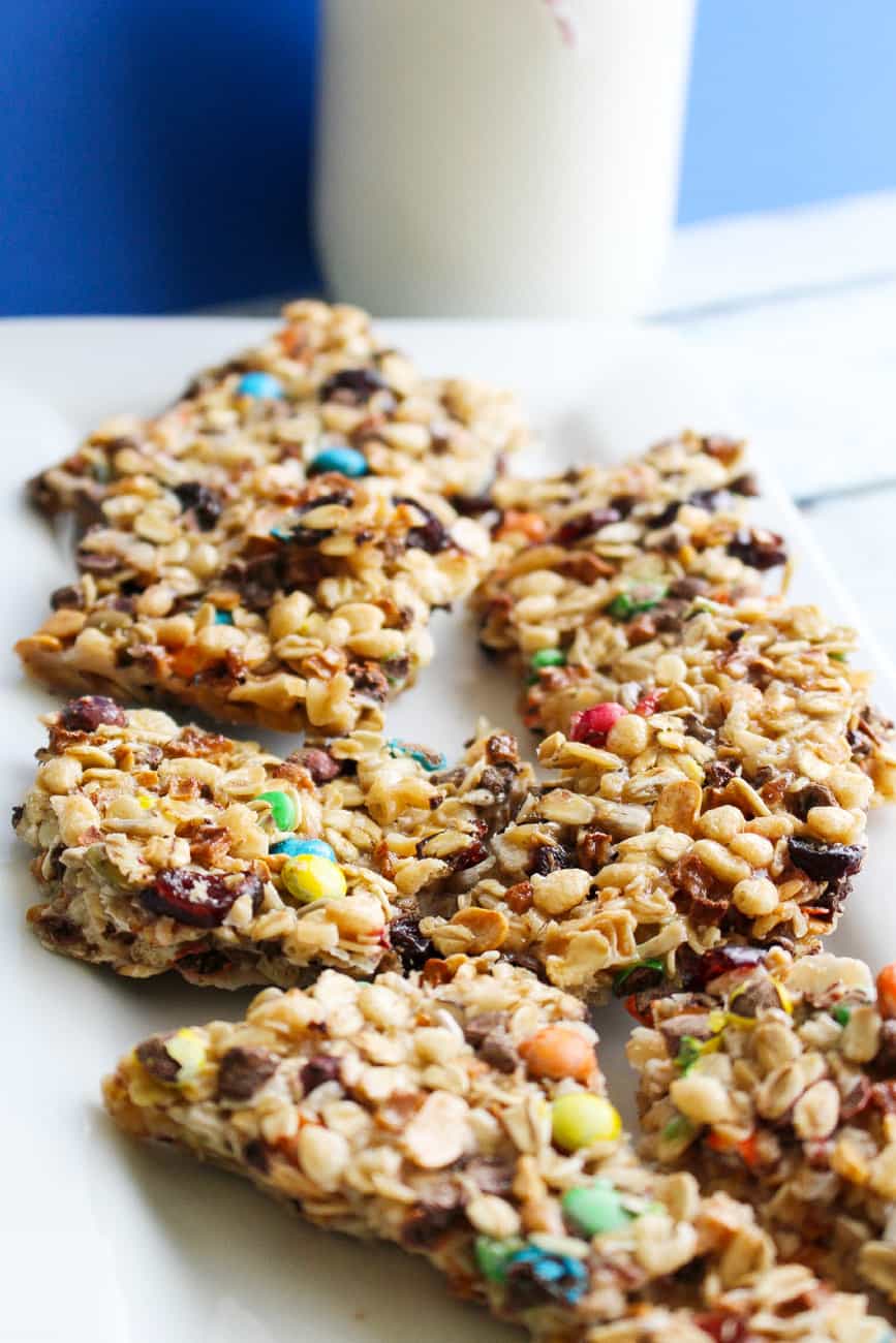 plate full of homemade granola bars with a glass of white milk in the background 