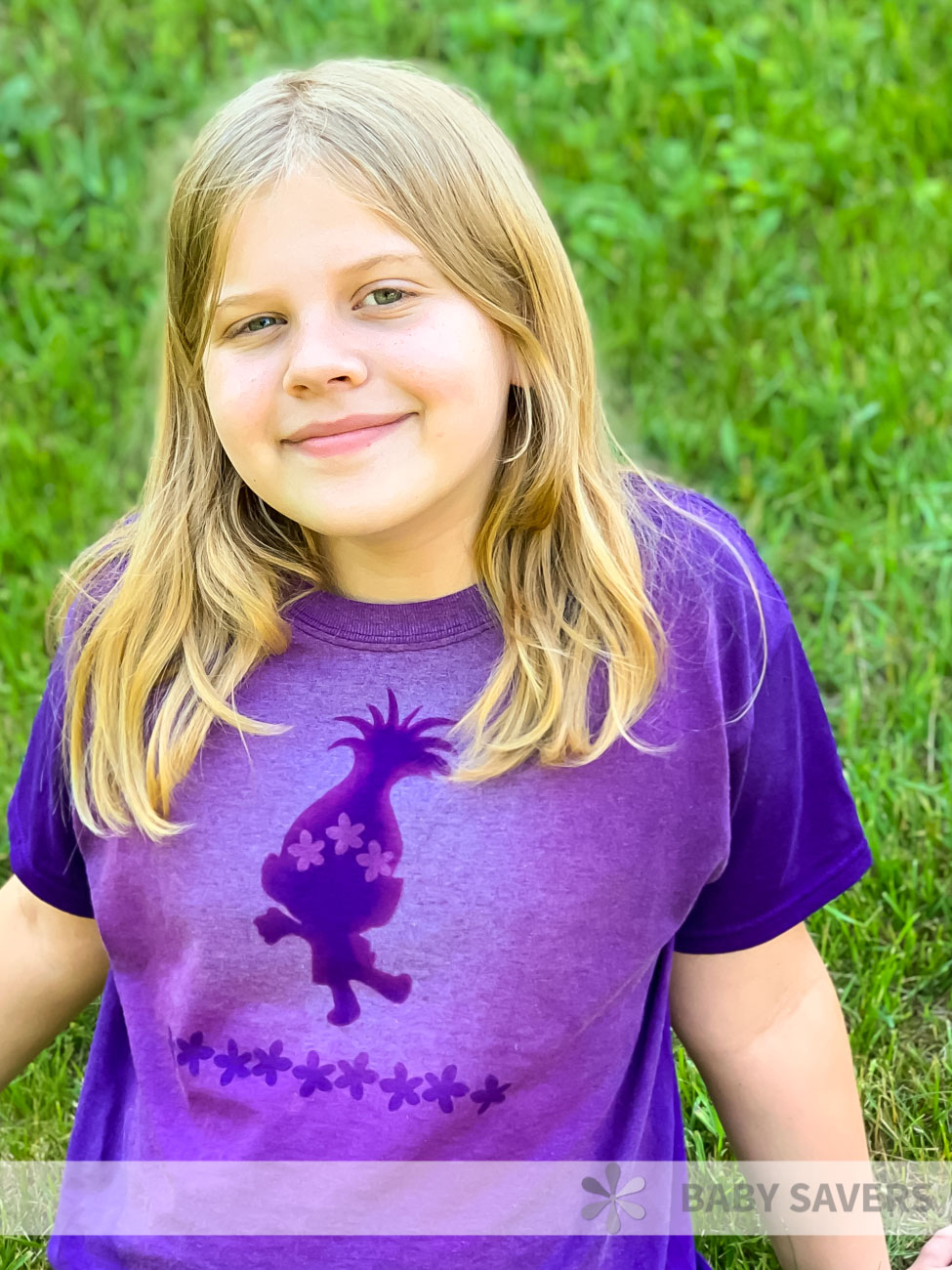 Girl wearing a purple bleach dyed shirt with a trolls shape