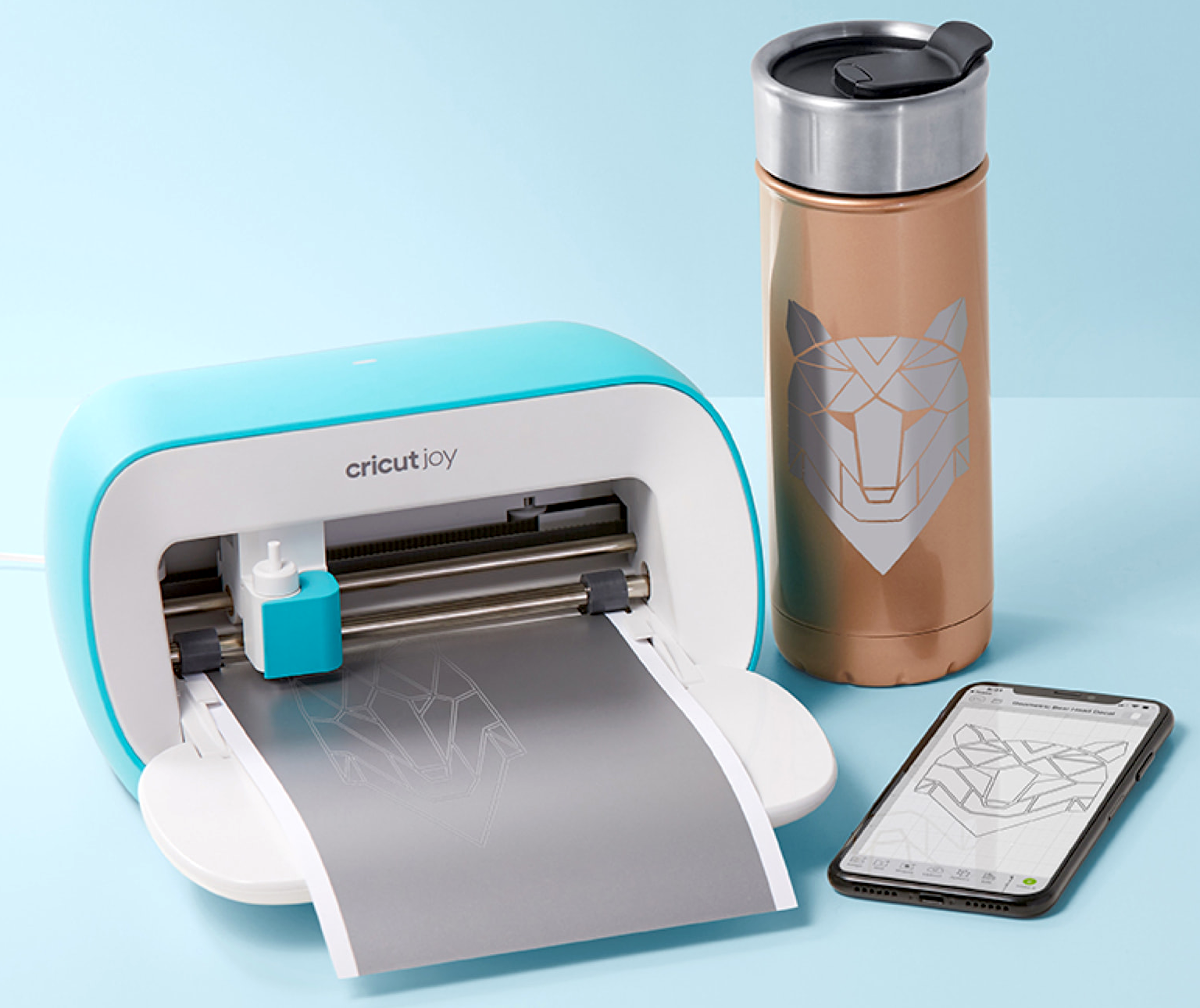Cricut joy cutting a silver decal with insulated mug and phone