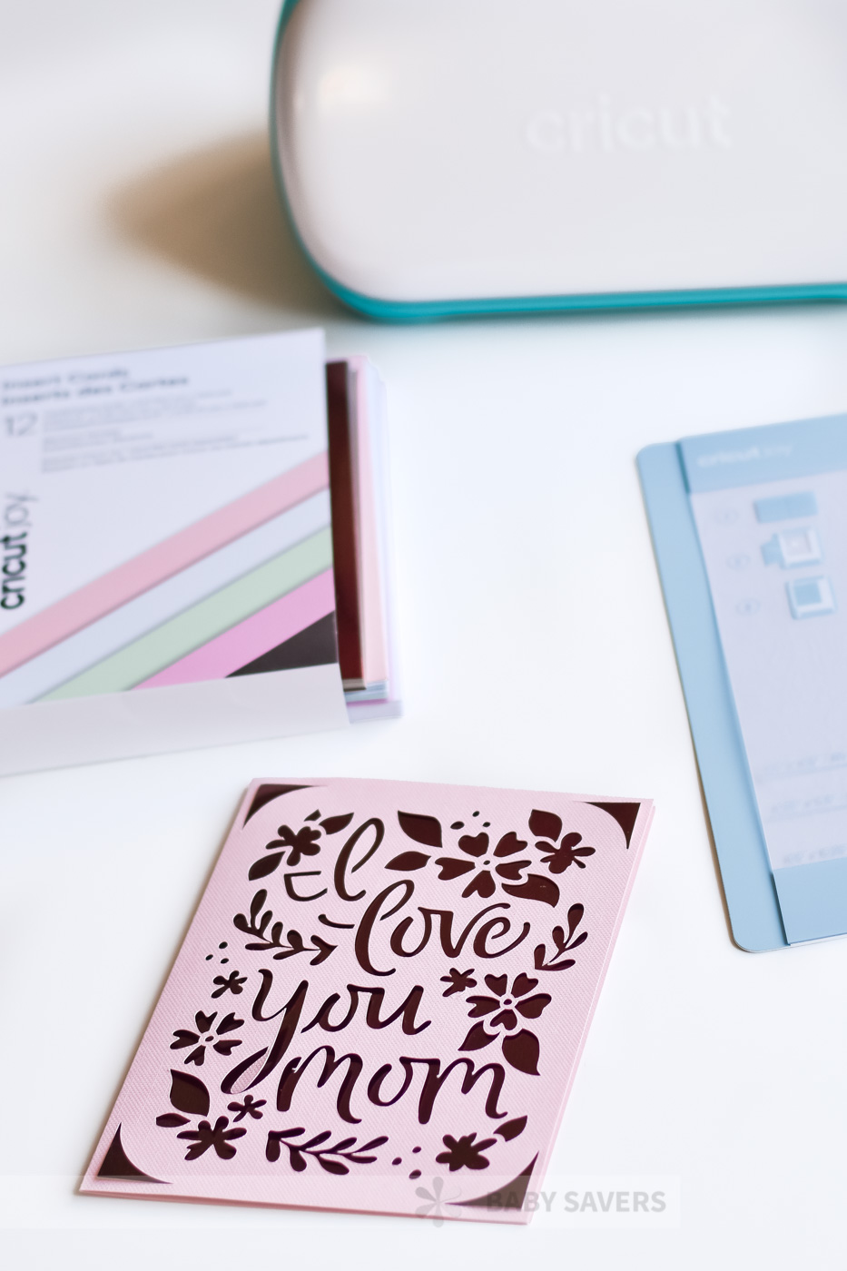 Pink card with Cricut Joy, card mat and box of materials 