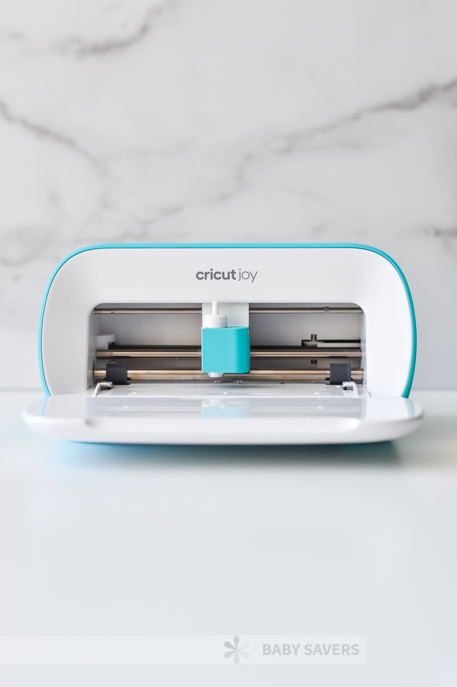 Open Cricut Joy cutting machine on a white marble background