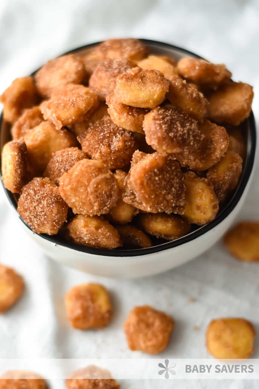 close up of cinnamon sugar covered sweet and salty snack mix in a white bowl