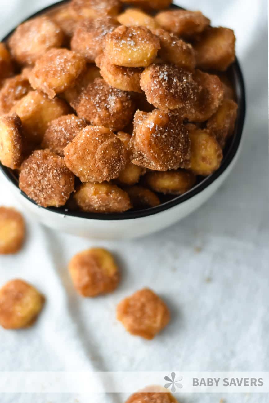 Sweet and salty snack mix in a white bowl on a white cloth napkin