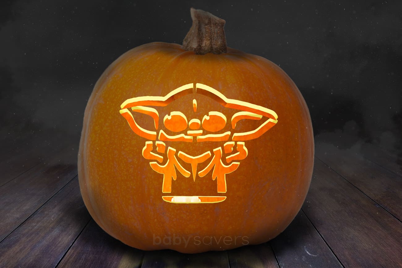 Baby Yoda pumpkin stencil carved onto an orange pumpkin