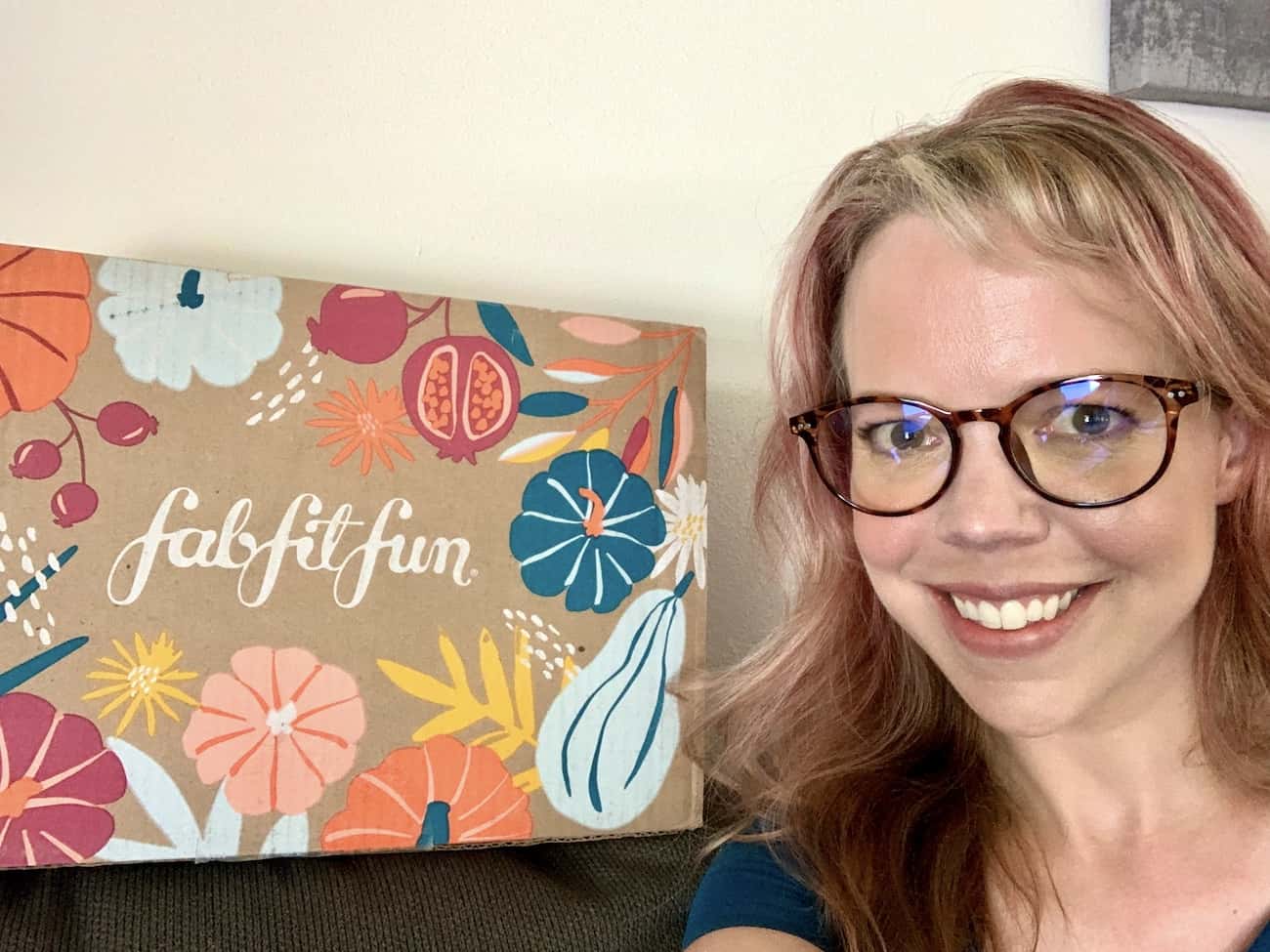 smiling woman wearing glasses with a FabFitFun box