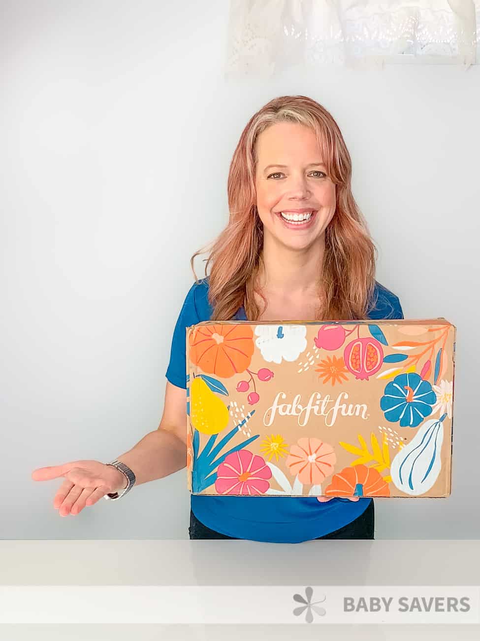 smiling woman holding fabfitfun fall box for 2020