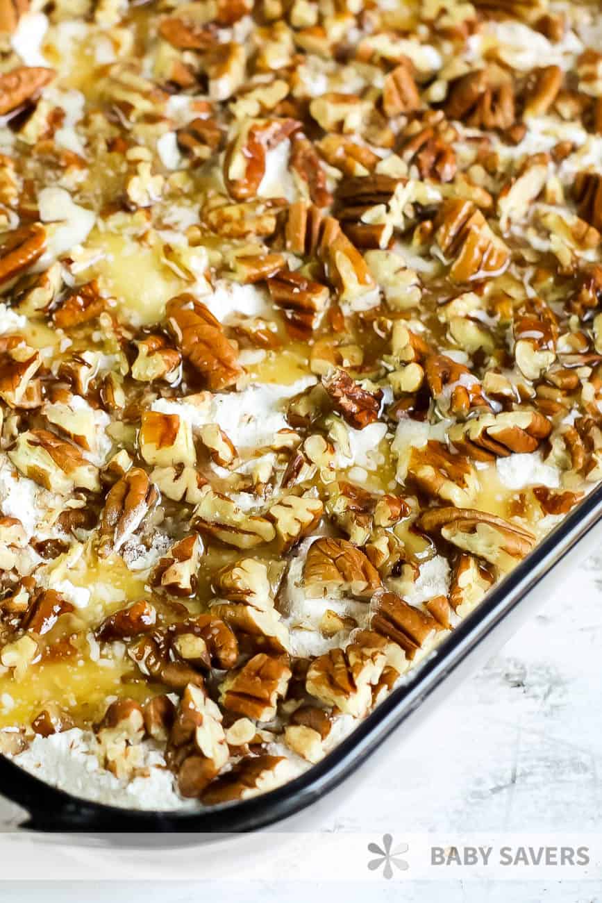 Unbaked pumpkin crisp topped with pecans and melted butter