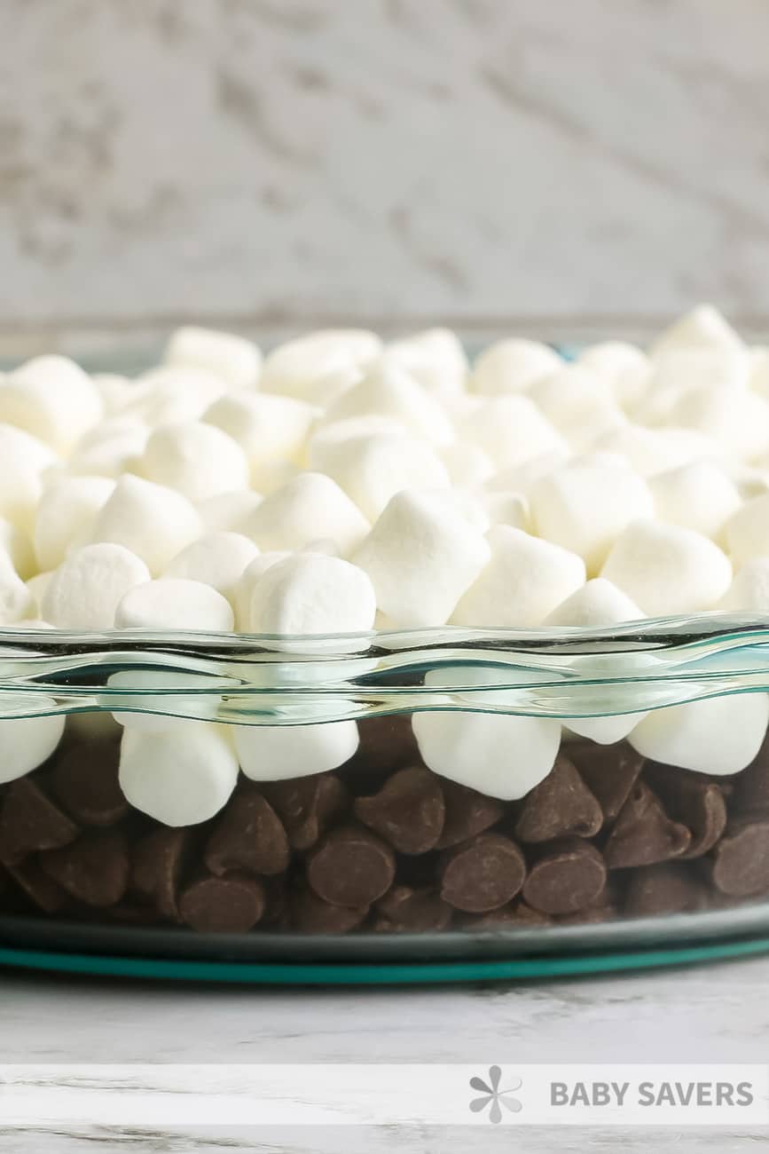 Layers of milk chocolate and marshmallows in a clear dish