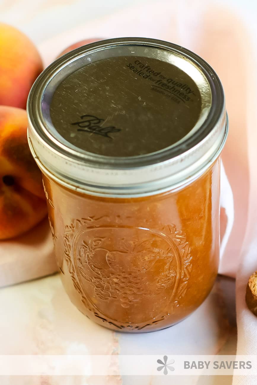 preserved and canned peach butter in a glass canning jar