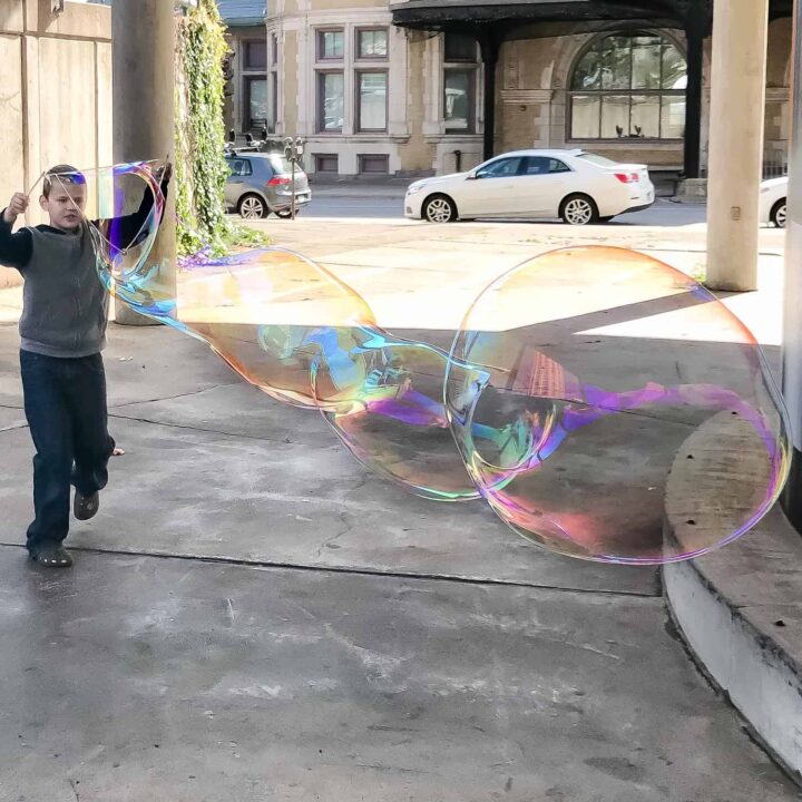 giant bubbles made by a boy with a string wand
