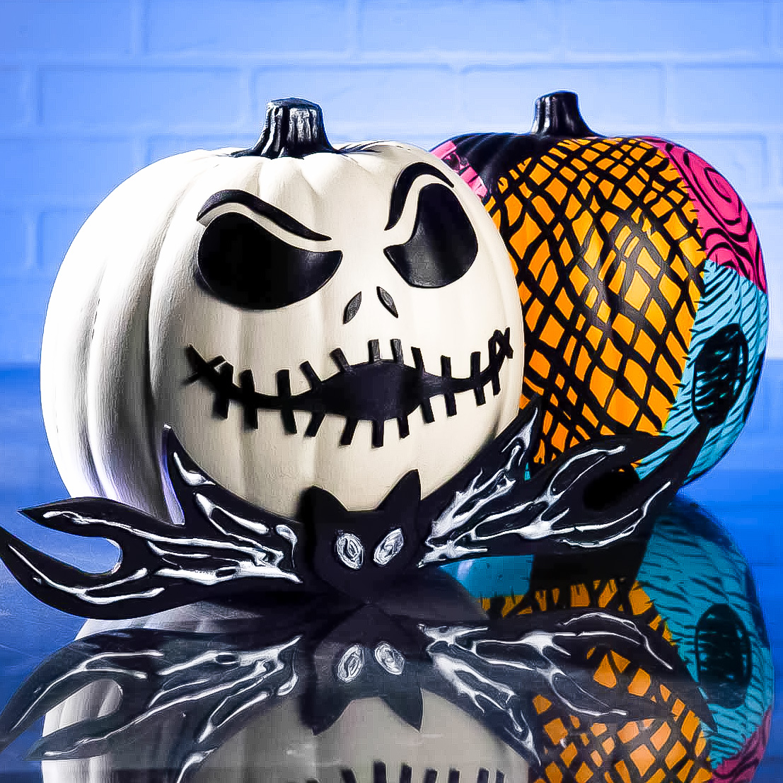 Jack Skellington pumpkin with a sally painted pumpkin behind it.