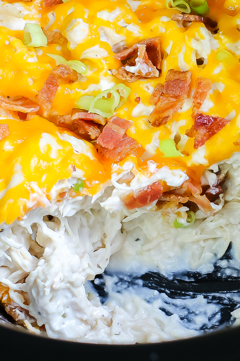 creamy crockpot chicken with cream cheese closeup with bacon, cheese, shredded cheese