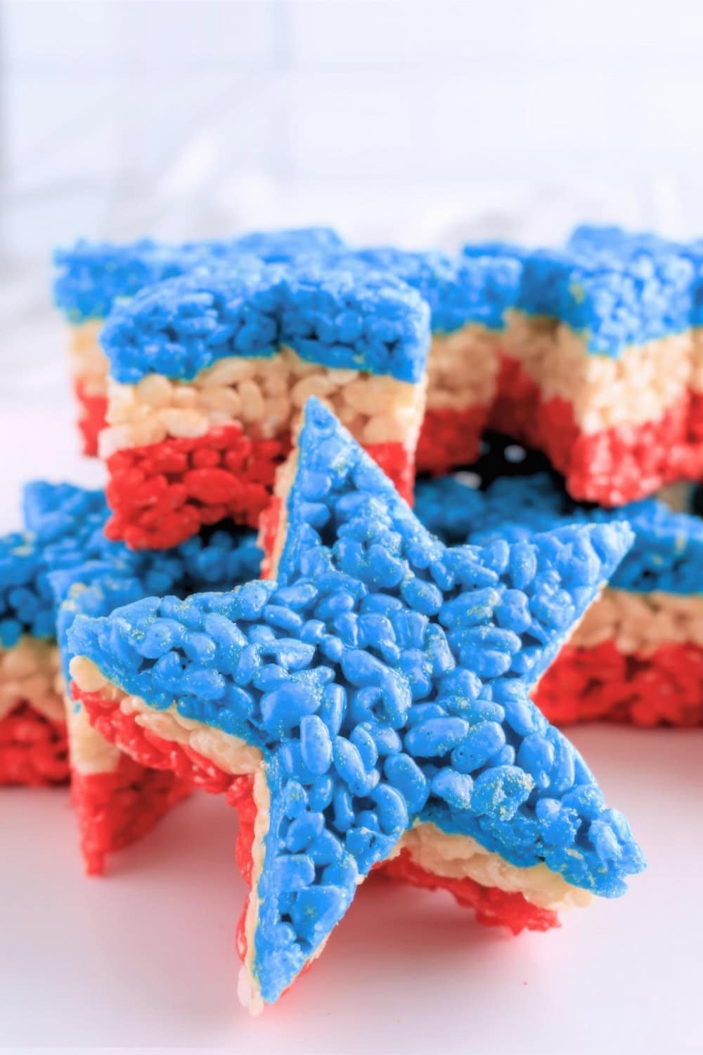 Star-shaped Rice Krispies treats with three layers in blue, white, and red are stacked festively, perfect for patriotic celebrations. These eye-catching Fourth of July recipes make any party extra special.