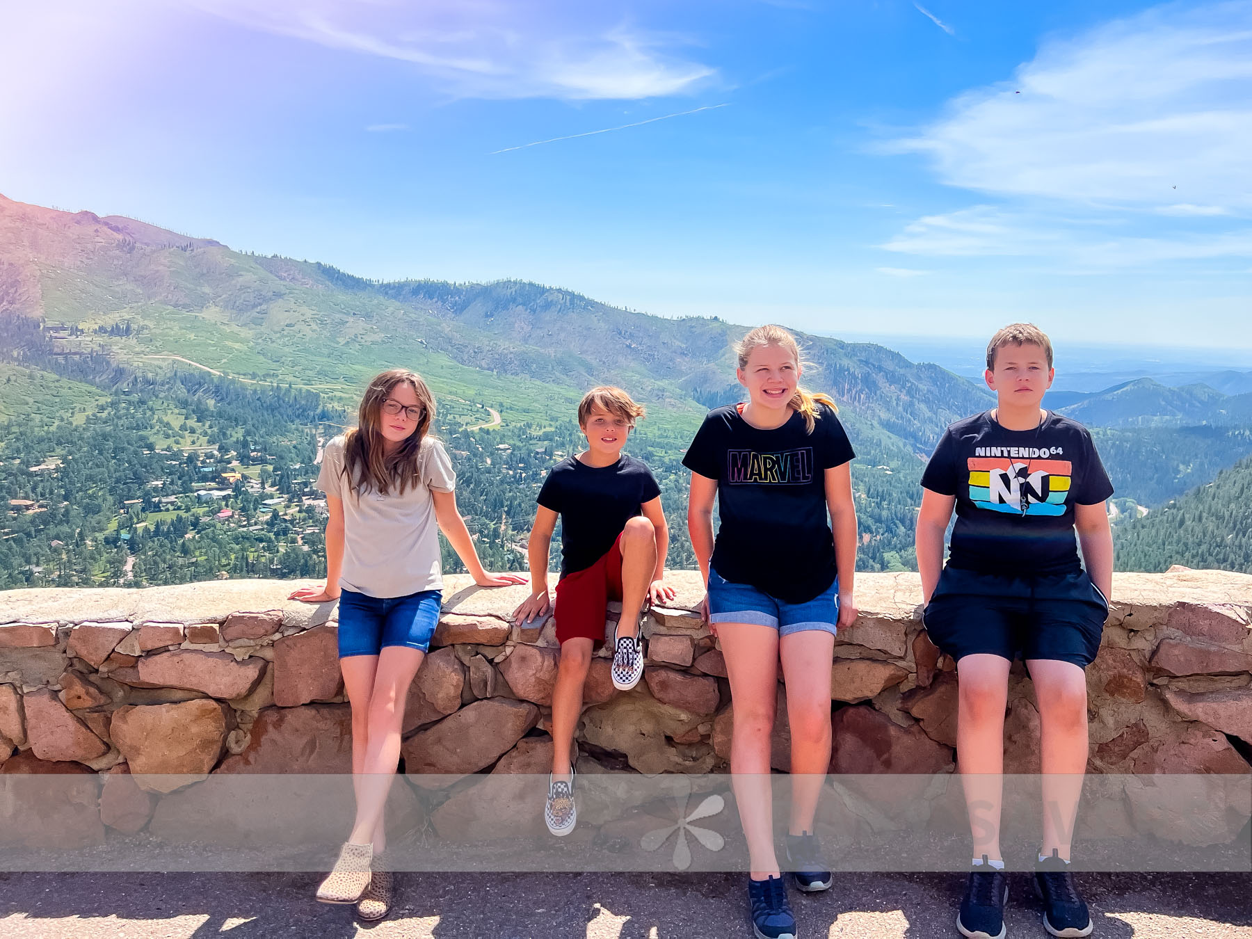 four kids posing for a family picture on vacation