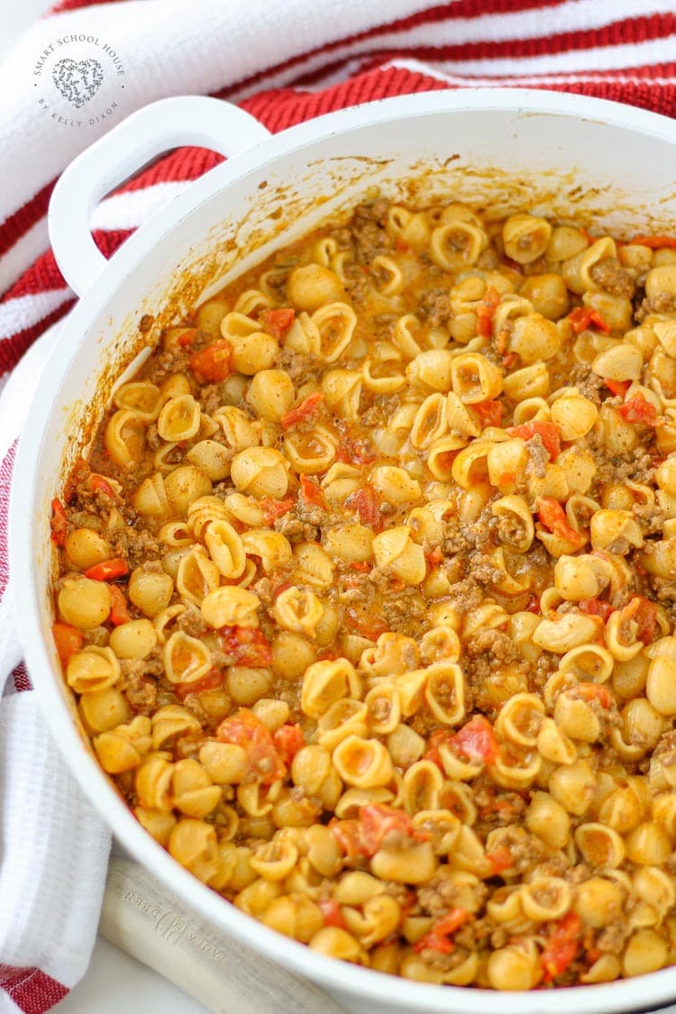 A pot of homemade American goulash with elbow macaroni, ground beef, diced tomatoes, and bell peppers—ideal for busy families. Freshly cooked and served in a white casserole