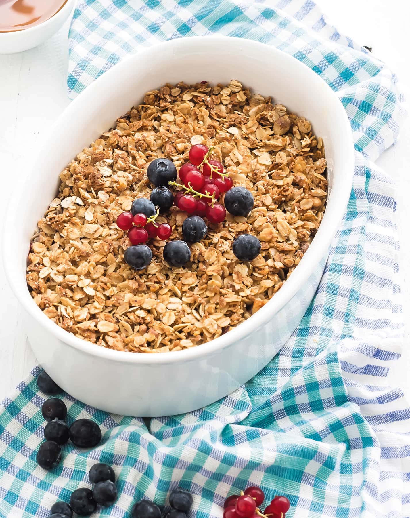 toddler breakfast idea baked oatmeal with blueberries and raspberries on a gingham towel