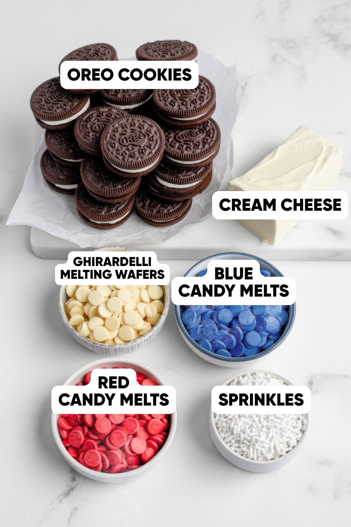 A stack of Oreo cookies, cream cheese, Ghirardelli melting wafers, blue and red candy melts, and white sprinkles are arranged on a marble surface—perfect for making Red White and Blue Oreo Balls, the ultimate Patriotic Desserts.