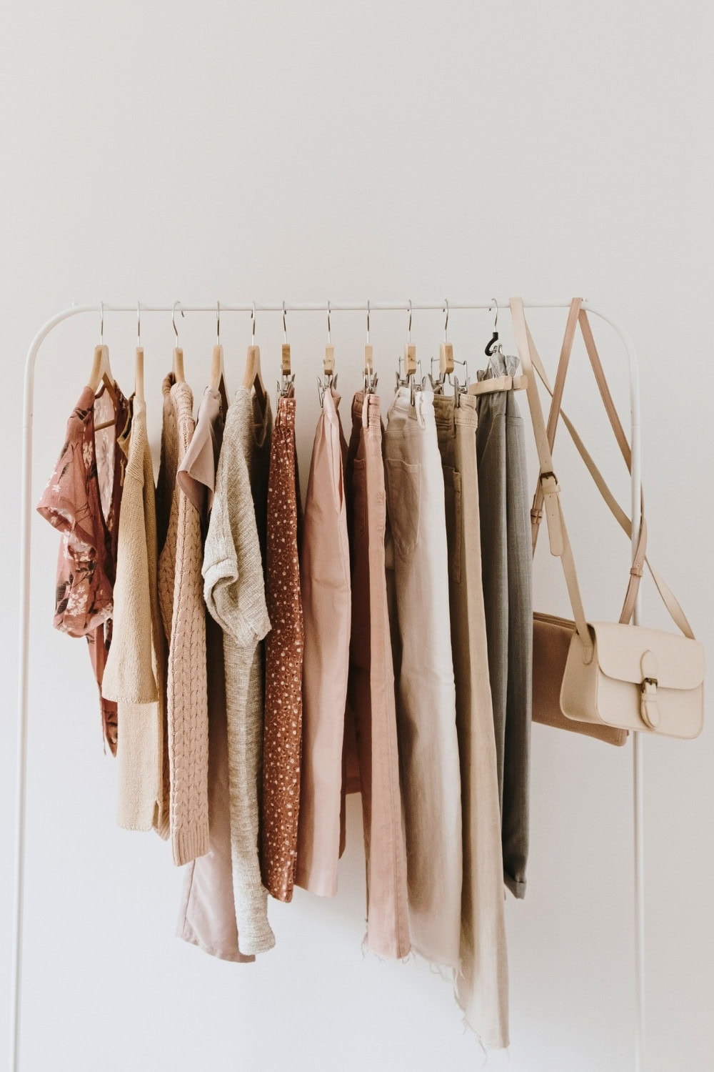 Soft neutral-colored clothing hanging on a minimalist white clothing rack from stitch fix